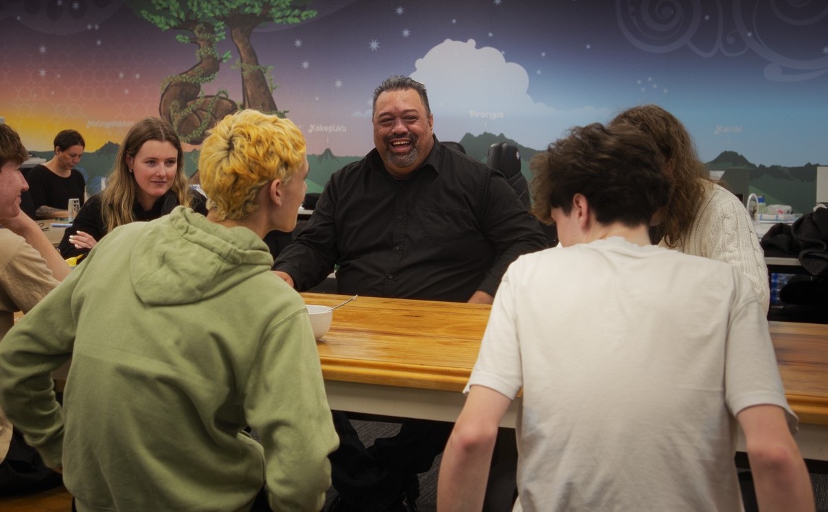 A group are sitting around a table chatting.